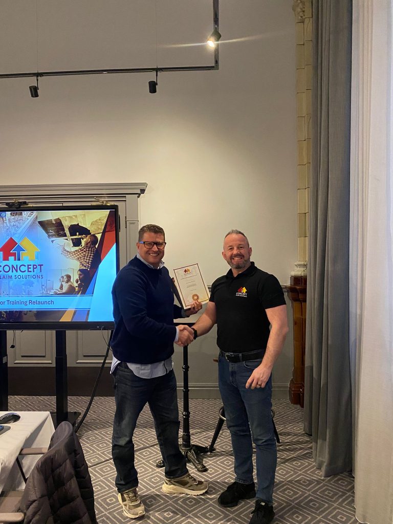 Two men shaking hands with a certificate beside a Concept Claim Solutions screen
